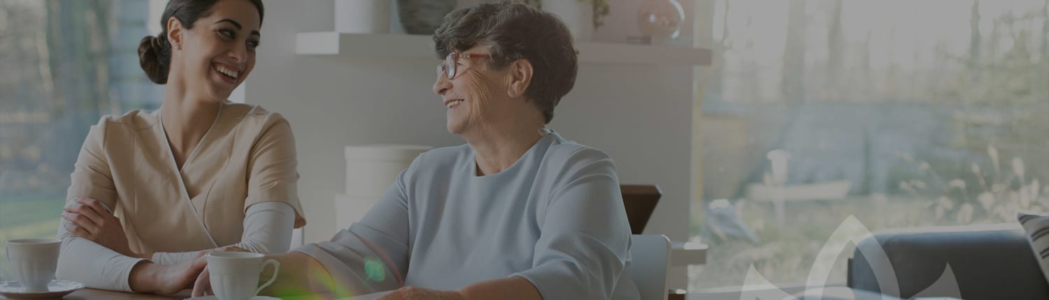 An older woman and younger woman engaging and interacting at a nursing home