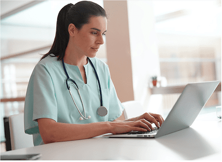 A nursing home nurse, CMA or CNA using a laptop at work (healthcare agency staffing)