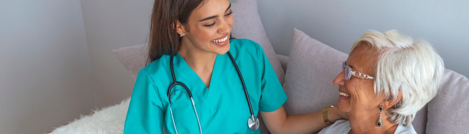 A nurse or CNA interacting with a patient in a nursing home or assisted living facility